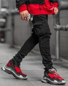 Primo piano di jeans cargo neri da uomo slim-fit con tasche laterali in stile street.