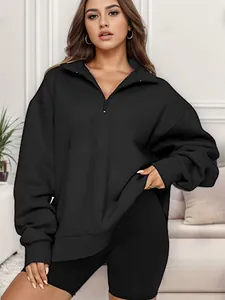 Dettaglio di una felpa oversize nera con mezza zip e pantaloncini da ciclista su modella.
