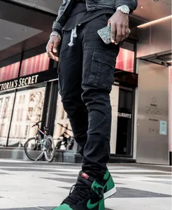Dettaglio dei jeans cargo neri slim fit da uomo in un contesto di moda urbana di strada