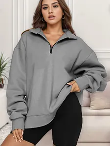 Dettaglio di una felpa grigia da donna con mezza zip, vestibilità morbida e collo alto