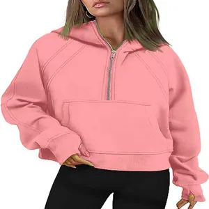 Detail of pink half-zip hooded cropped sweatshirt with front pocket and long sleeves.