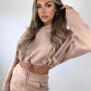 Model trägt ein stylisches beiges zweiteiliges Lounge-Set mit kurzem Kapuzenpullover