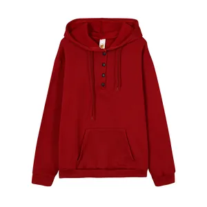 Detailed view of a solid red oversized hoodie with black button placket and kangaroo pocket.