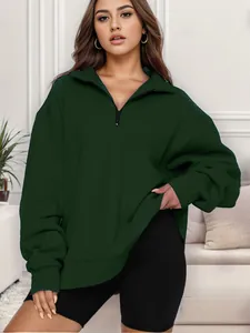 Dettaglio di una felpa oversize da donna verde scuro con mezza zip per un look casual