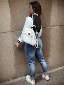 Stylish black and white color-block varsity jacket for women shown from a back perspective
