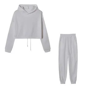 Minimalistischer weißer zweiteiliger Trainingsanzug mit kurzem Kapuzenpulli und Jogger.