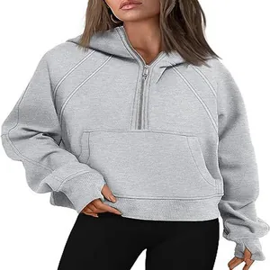 Detail view of gray half-zip hooded sweatshirt featuring thumbholes and front pocket