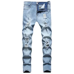 Detailed view of men's slim fit light blue ripped jeans with distressed details