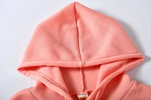 Close-up detail showing the soft fleece texture and hood of a pink drawstring hoodie