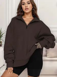 Vista frontale della felpa oversize marrone cioccolato con mezza zip sulla modella