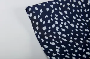 Nahaufnahme von dunkelblauem Kleiderstoff mit weißem unregelmäßigem geometrischem Muster