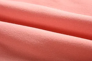 Macro detail shot of soft pink knit sweatshirt fabric showing fine texture and jersey weave