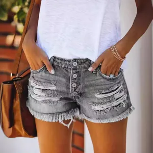 Trendy women's distressed denim shorts featuring a button fly and stylish fringe hem in grey wash.