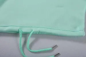 Detail eines minzgrünen Hoodies mit Kordelzug, Metallenden und weicher Stricktextur