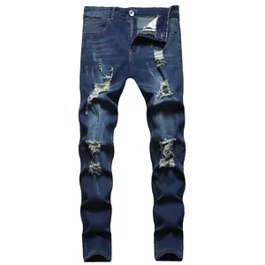 Detailed view of men's distressed blue jeans featuring a slim fit and ripped knee accents