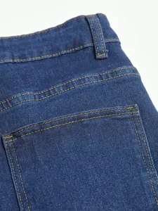 Gros plan d'un jean bleu classique montrant les coutures détaillées sur la poche et la taille
