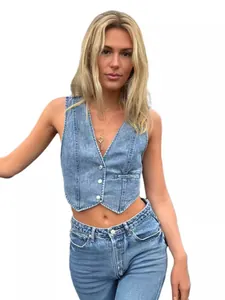 Detailed view of fashionable blue washed denim vest on model with V-neck and buttons