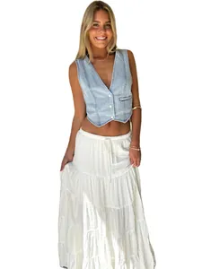 Chic light blue denim vest paired with a tiered white maxi skirt for a casual summer look.
