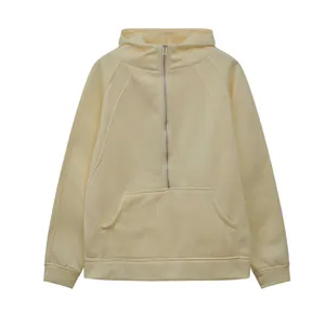 Close-up of a light yellow half-zip hoodie featuring a kangaroo pocket and ribbed cuffs.