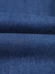 Gros plan macro sur la texture du tissu denim extensible bleu foncé pour jeans homme