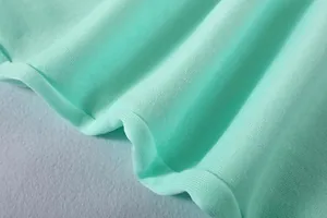 Makroaufnahme der weichen minzgrünen Strickstofftextur für lässige Sportbekleidung