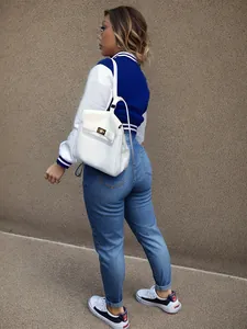 Detailed view of the stylish blue and white colorblock varsity jacket worn by model.
