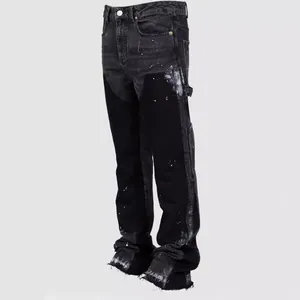 Detailed view of men's stacked flare jeans with white paint splatter and patchwork design