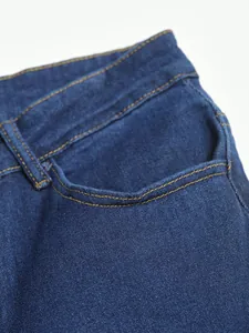 Détail rapproché d'un jean bleu stretch montrant la poche et les coutures contrastées
