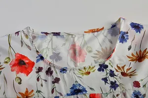 Nahaufnahme des Rundhalsausschnitts und des bunten Blumenmusters an diesem Damenkleid