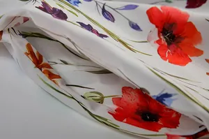 Makrodetail aus hochwertigem Stoff mit rotem Mohnblumenmuster für herbstliche Kleider