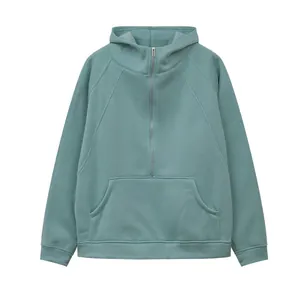 Detail view of a sage green half-zip hooded sweatshirt with a soft fleece texture.