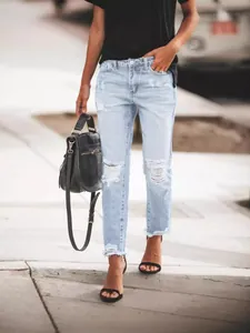 Fashionable light blue vintage high waist ripped jeans for women in a street style look