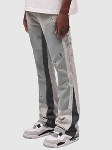 Detailed view of men's carpenter flare jeans with patchwork and paint splatter accents.