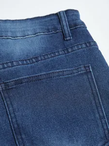 Detailed macro view of back pocket and stitching on men's slim fit stretch blue denim jeans