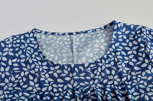 Detailansicht des Rundhalsausschnitts und des Blumenmusters auf einem blauen Kleid