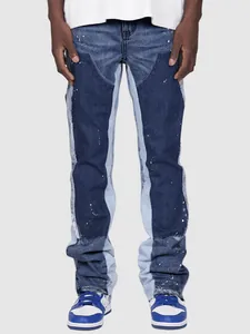 Detailed front view of men's patchwork stacked flare denim pants with paint splatters