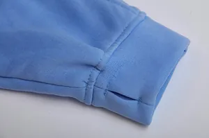 Macro close-up of light blue fleece hoodie ribbed cuff with functional thumbhole detail