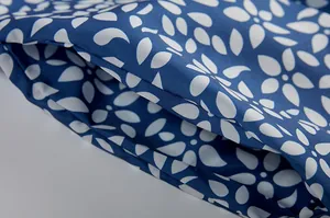 Detailansicht des blau-weißen Blumenmusters und der praktischen Seitentasche des Kleides.