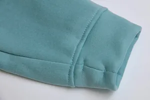 Close-up of teal fleece hoodie sleeve featuring a functional thumbhole cuff design