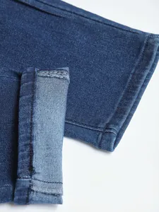 High-quality close-up of the hem and stitching detail on men's slim stretch denim jeans.