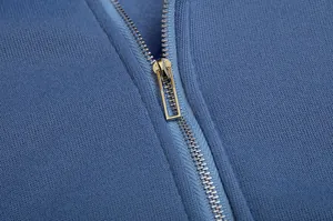 Macro detail showing the smooth metal zipper on a high-quality blue fleece hooded sweatshirt
