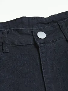 Macro view showing the waistband and silver button of black slim-fit denim jeans.