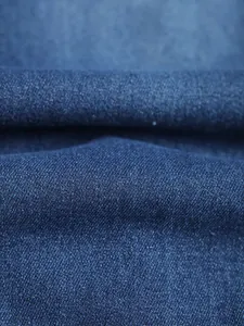 Macro detail showing the high-quality woven blue denim fabric texture of men's jeans