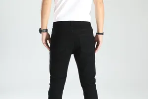 Vista posteriore di jeans neri slim fit da uomo con un classico design a cinque tasche