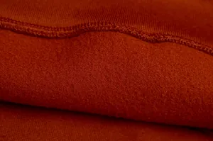 Close-up macro detail showing the soft and warm red fleece lining of the hooded sweatshirt