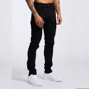 Vue détaillée d'un jean skinny noir pour homme avec des baskets blanches sur un mannequin