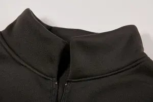 Dettaglio del colletto rialzato e della mezza zip su una felpa sportiva nera da donna.
