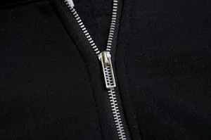 Close-up detail of the durable silver metal half-zipper on the black fleece sweatshirt