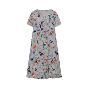 Detailansicht eines weißen Kurzarmkleids mit lebhaften orangefarbenen und blauen Blumenprints.