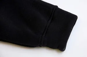 High-quality detailed close-up showing the ribbed cuff texture of a black fleece sweatshirt